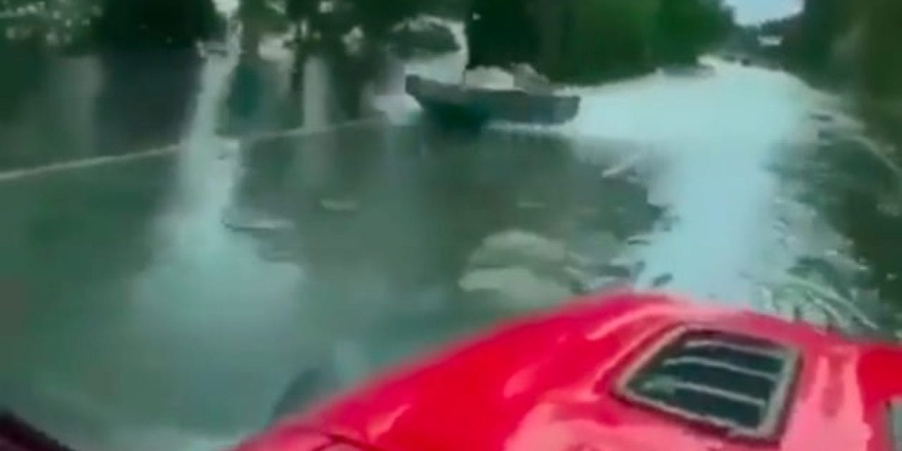 Driver Passes Quick-Moving Jet Boat on a Flooded Highway