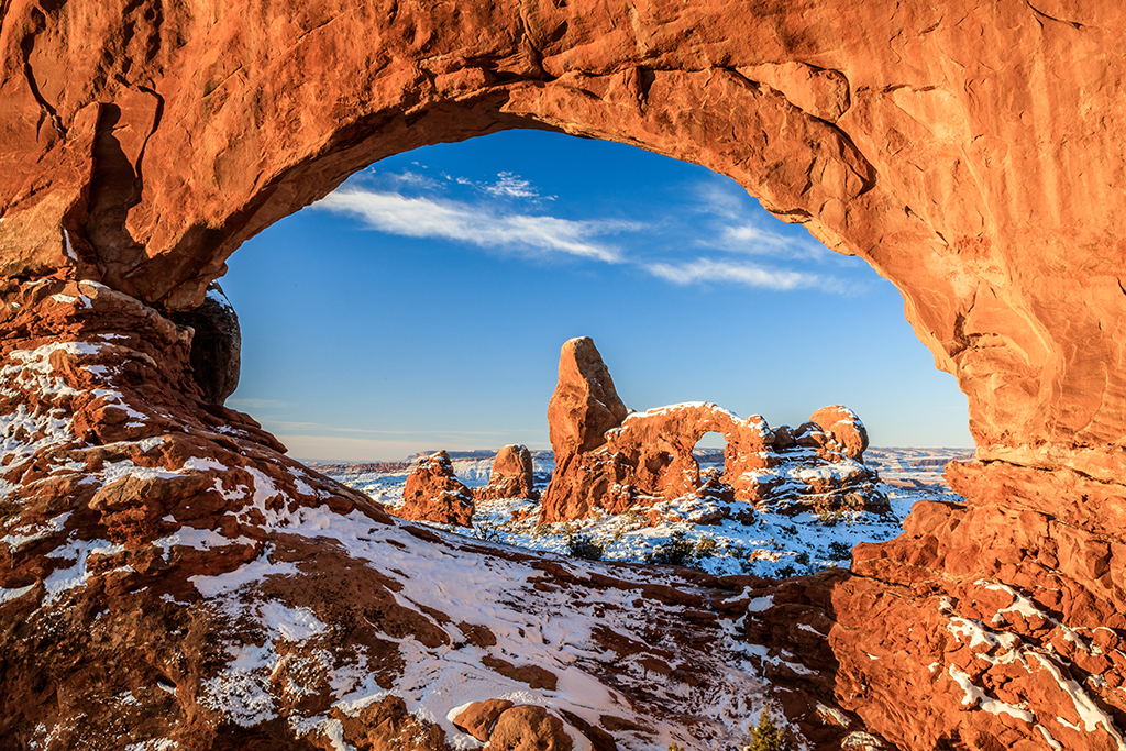 Image of a view through Turret Arch with a dusting of snow in Arches National Park.