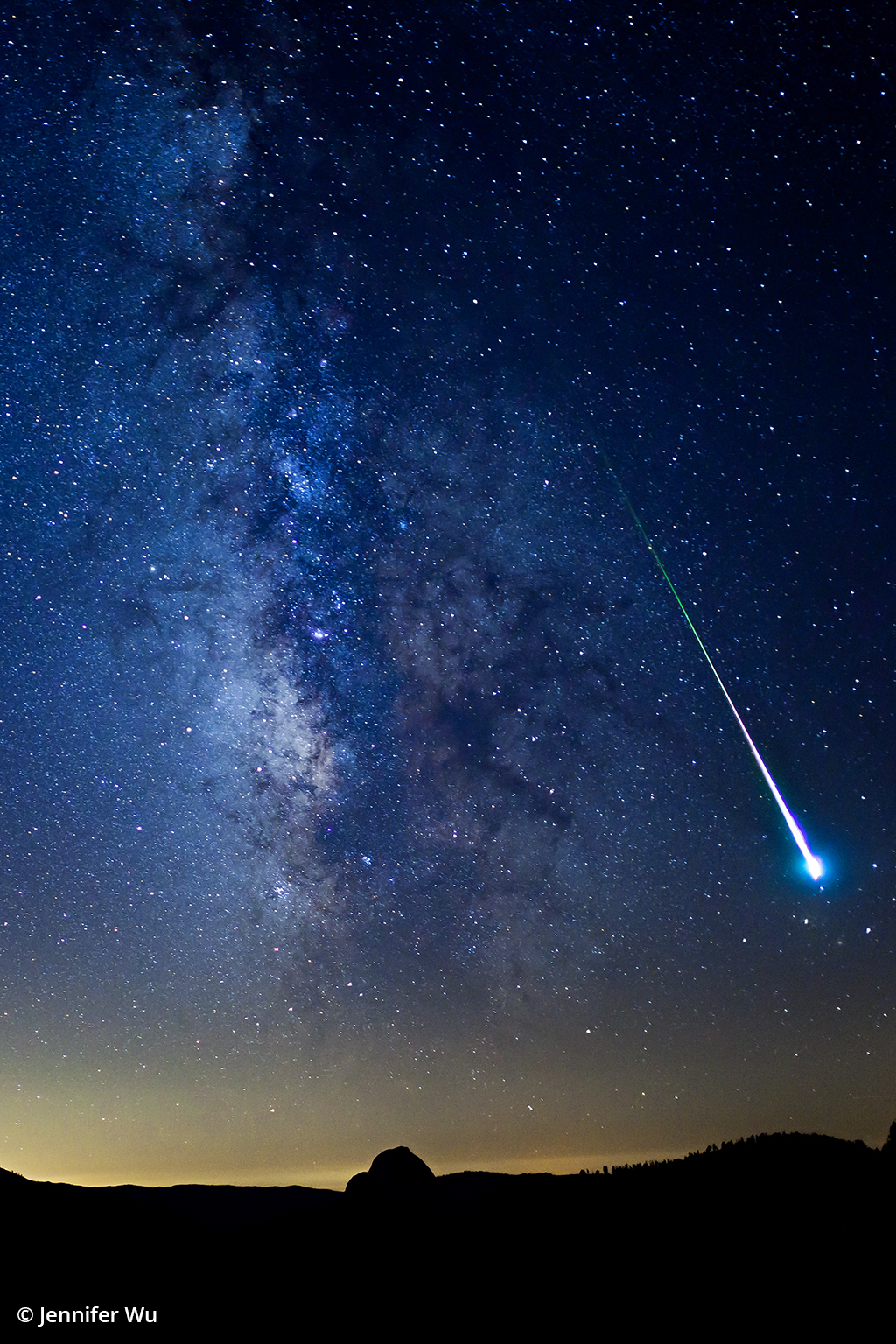 Night sky photo of a meteor above Half Dome in Yosemite.