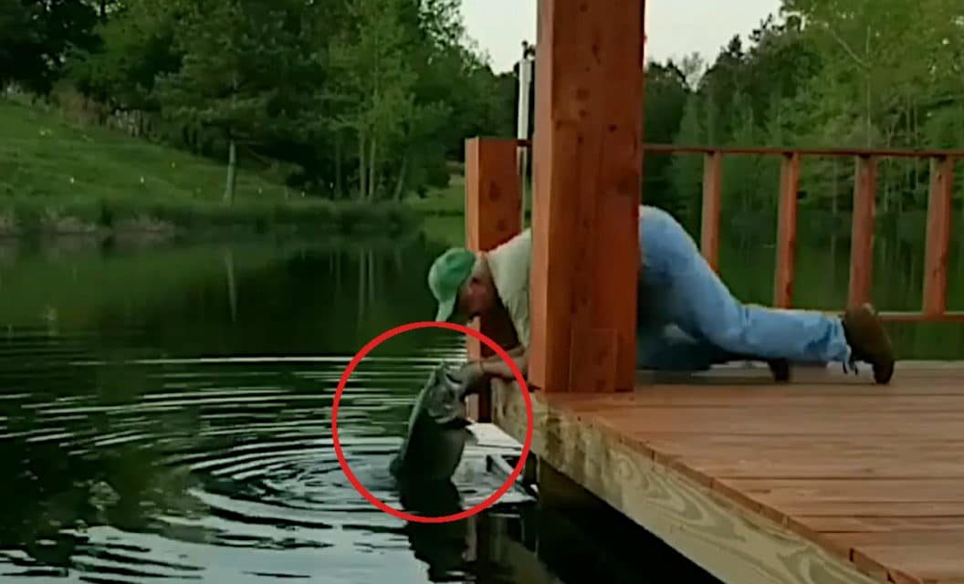 Man Grabs Two Monster Bass By Hand Off a Dock