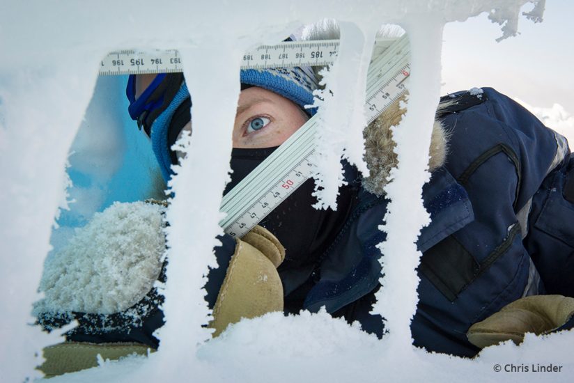 A researcher measuring icicles