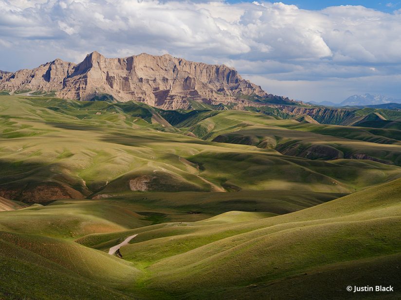 Photo of sandstone cliffs over alpine pastures, Naryn Province, Kyrgyzstan