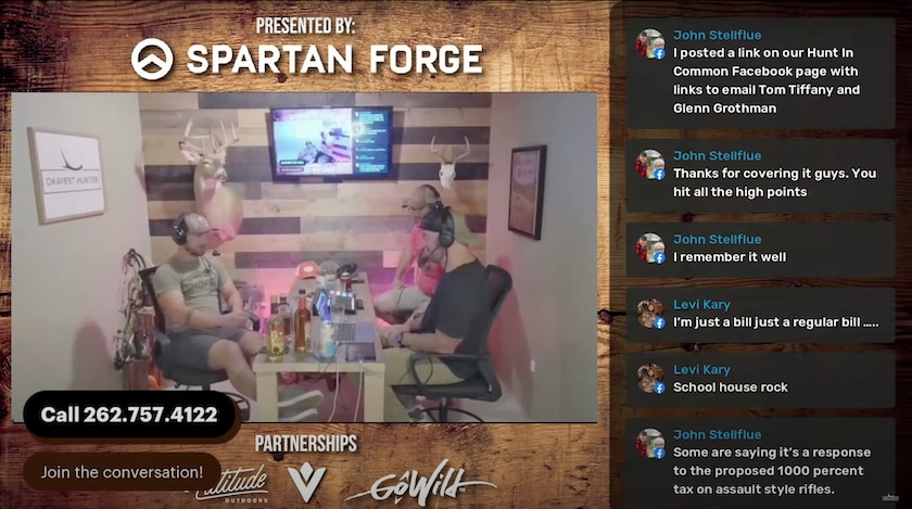 screenshot of livestream. three men sit at table talking. live chat box on right side of screen