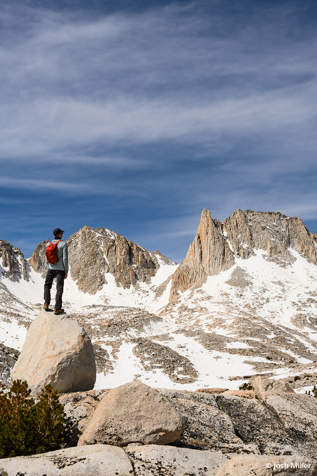 Photo of a backpacking photographer standing on a rock