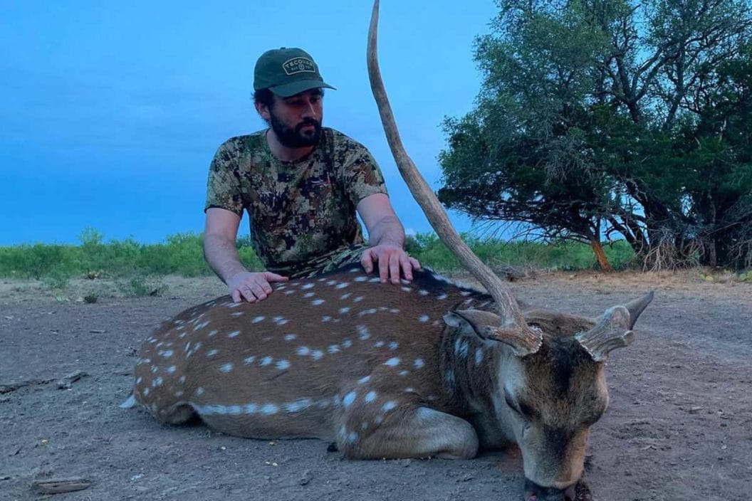 Hunter with a harvested axis deer from the Texas Hill Country.