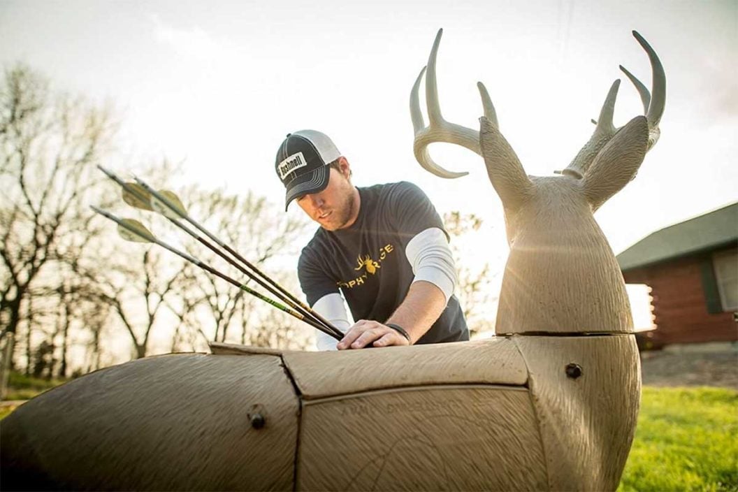 Archer pulls arrows out of a 3D deer archery target