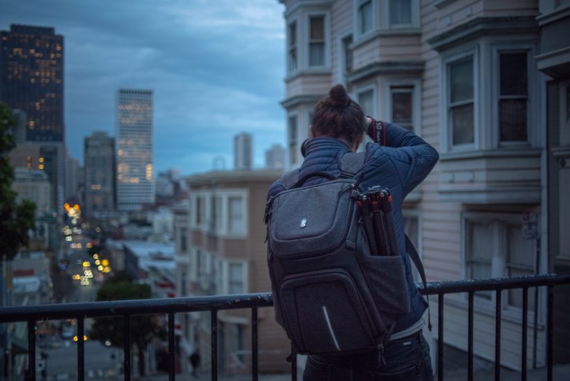Photo illustrating use of the K&F CONCEPT Alpha backpack's side pocket to carry a tripod