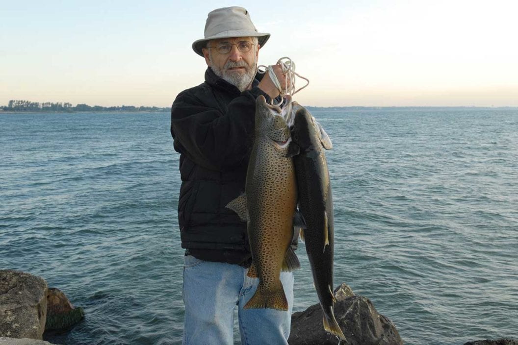 An angler holds brown trout caught from Lake Michigan