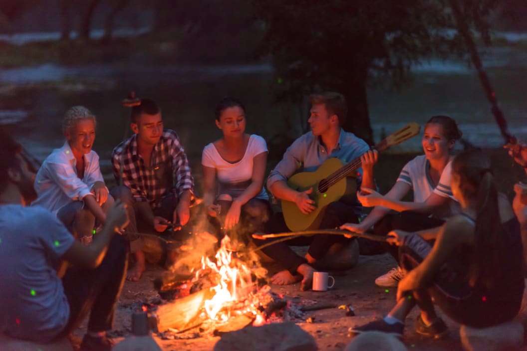 people sit around a campfire
