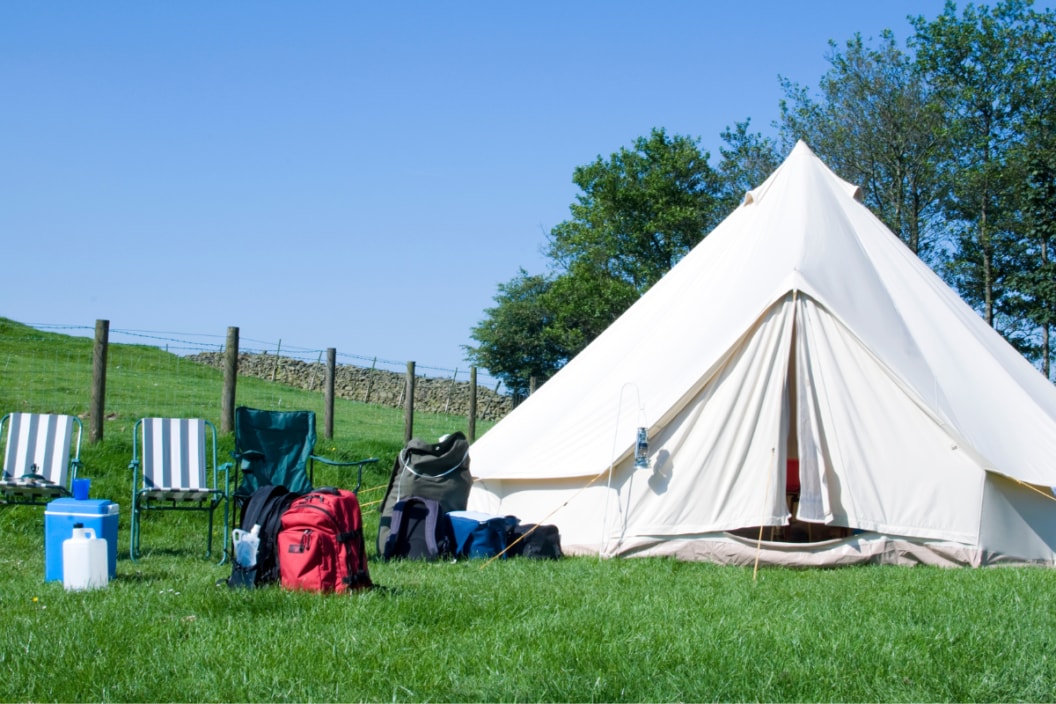 tent and camping gear sitting in a field