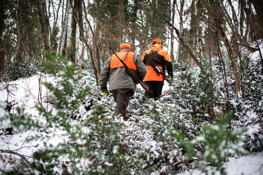 two men walking through snowy woods