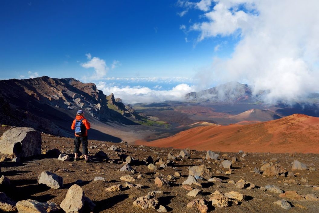 Tourist hiking in Haleakala volcano crater on the Sliding Sands trail. Beautiful view of the crater floor and the cinder cones below