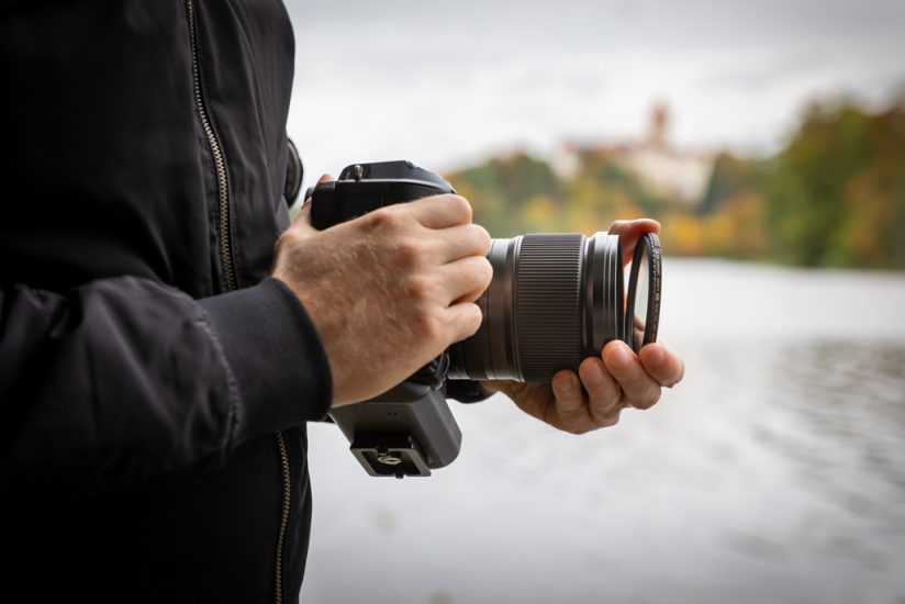 Photo of a photographer removing a camera lens filter.