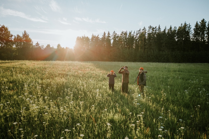 three hunters in field